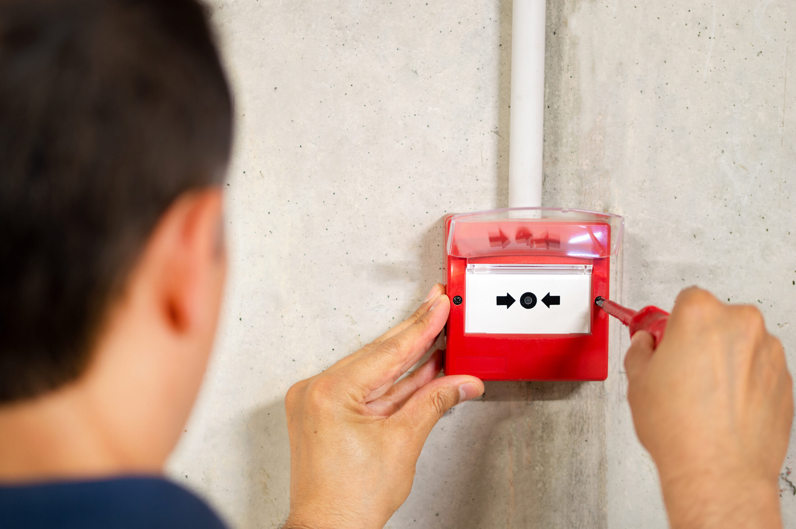 Technician installing manual call point fire alarm