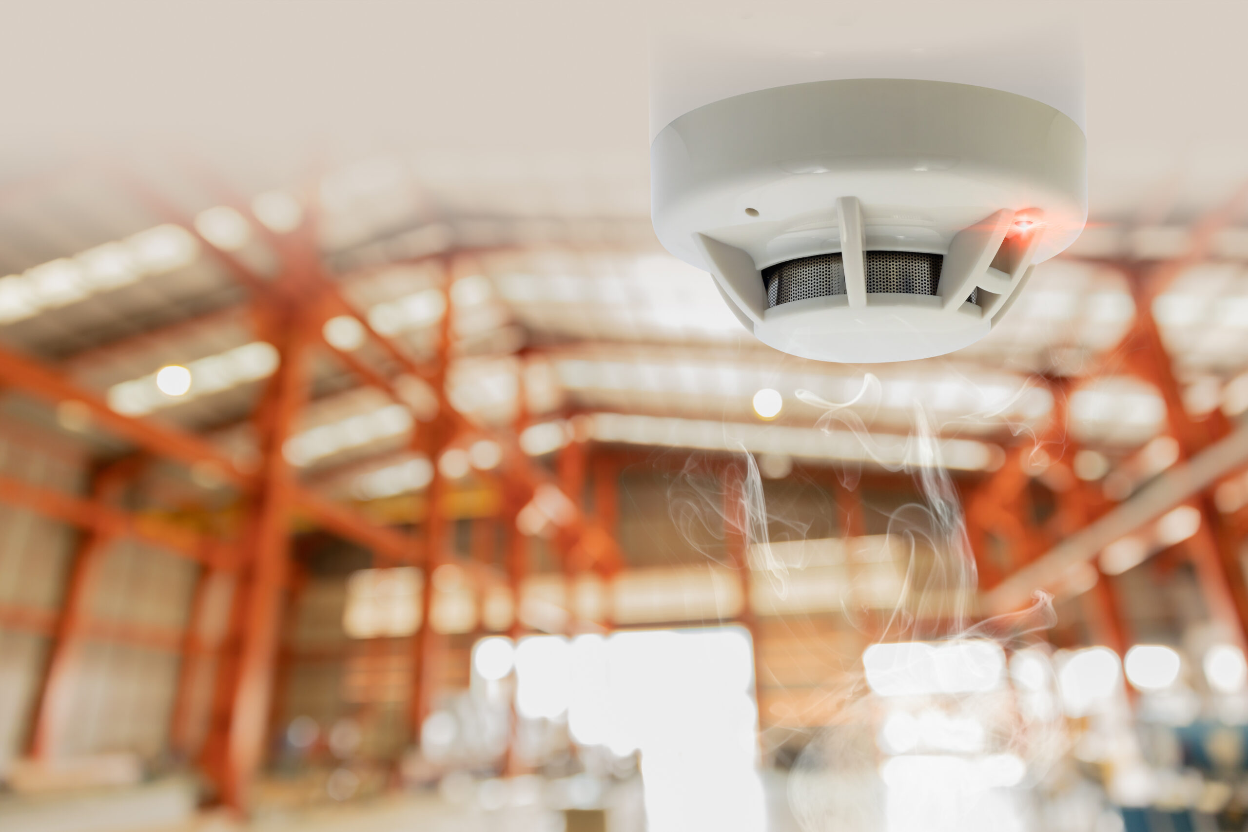 Smoke Rising to a fire alarm in a warehouse